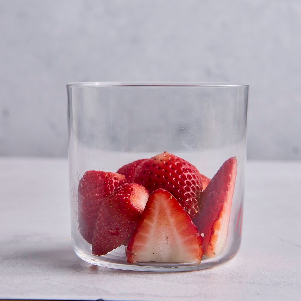 Fresh strawberries in a small glass dessert cup.