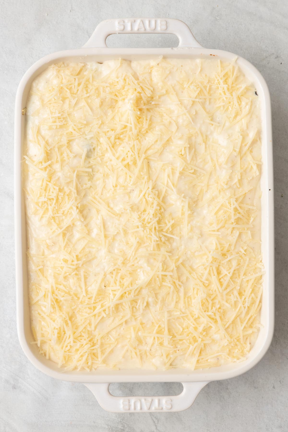 Another layer of eggplant added with bechamel sauce smoothed over and topped with parmesan cheese before baking.