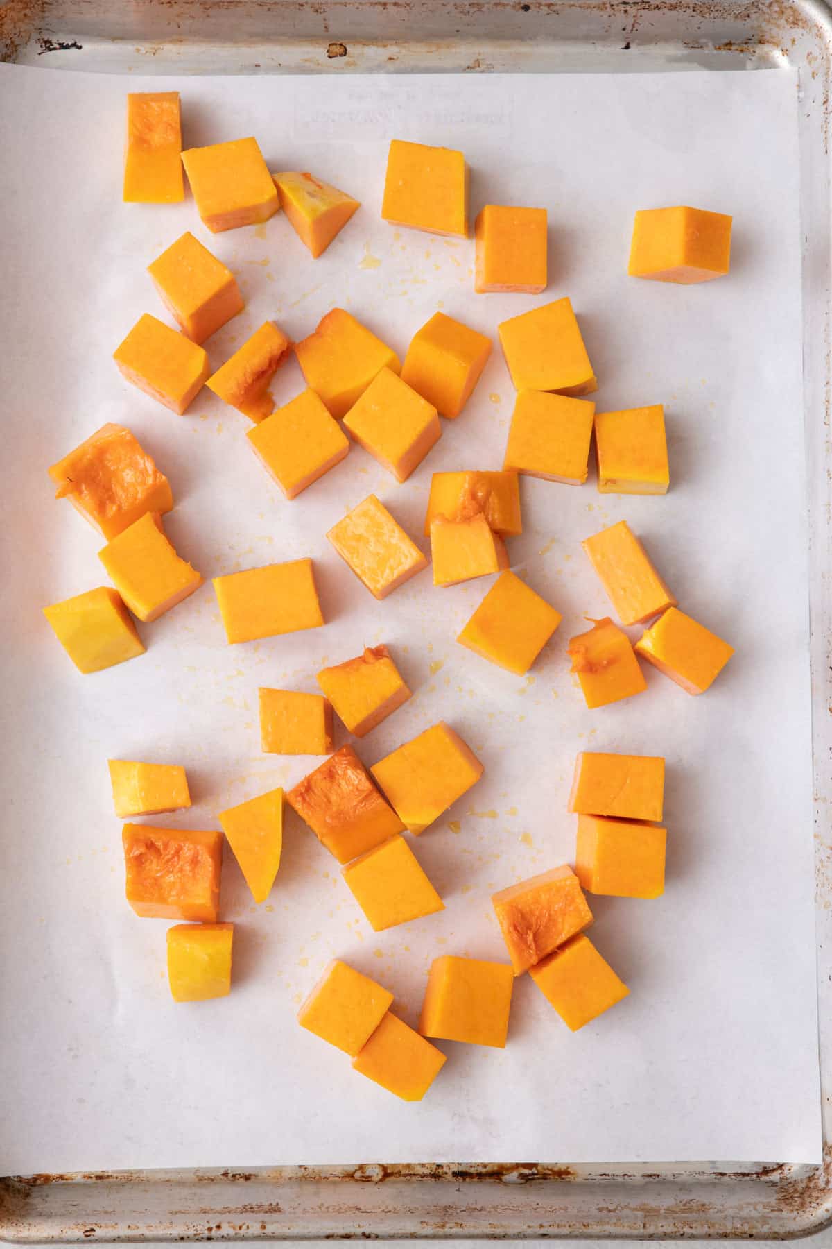 Butternut squash cubes on a sheet pan.