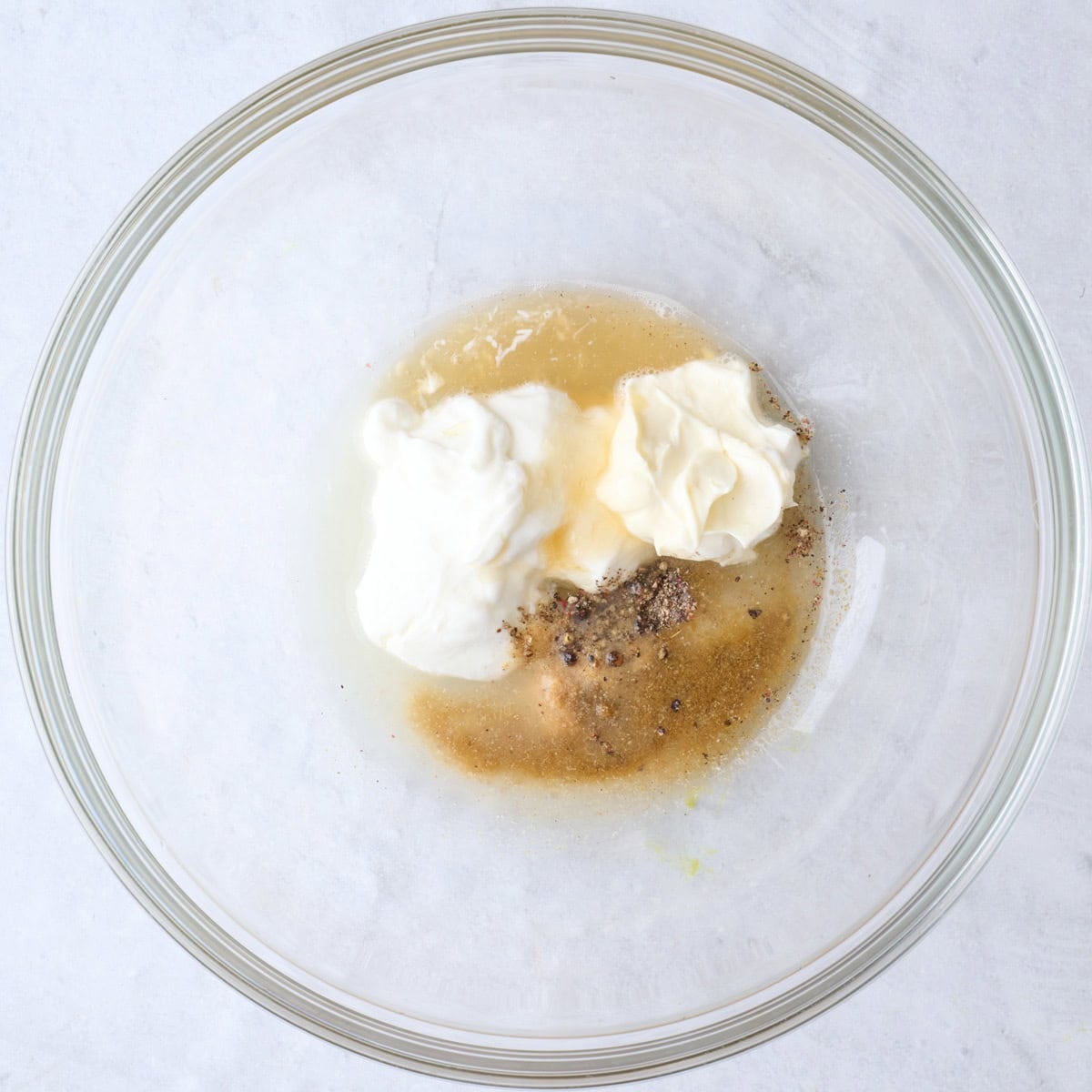 Dressing ingredients in a bowl before mixing.