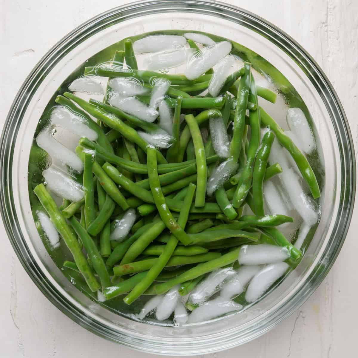 Green beans in a bowl of ice water.