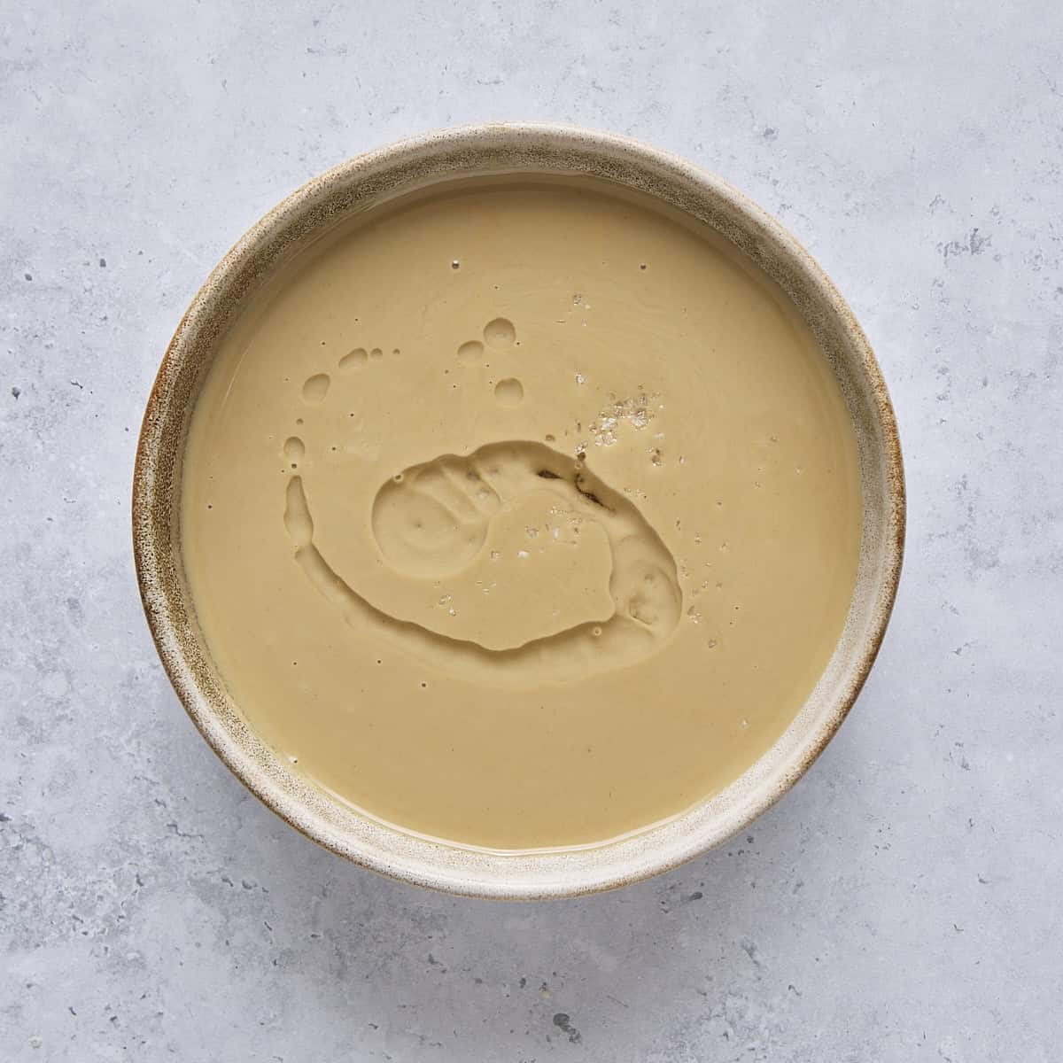 Tahini, rose water, and salt in a bowl.