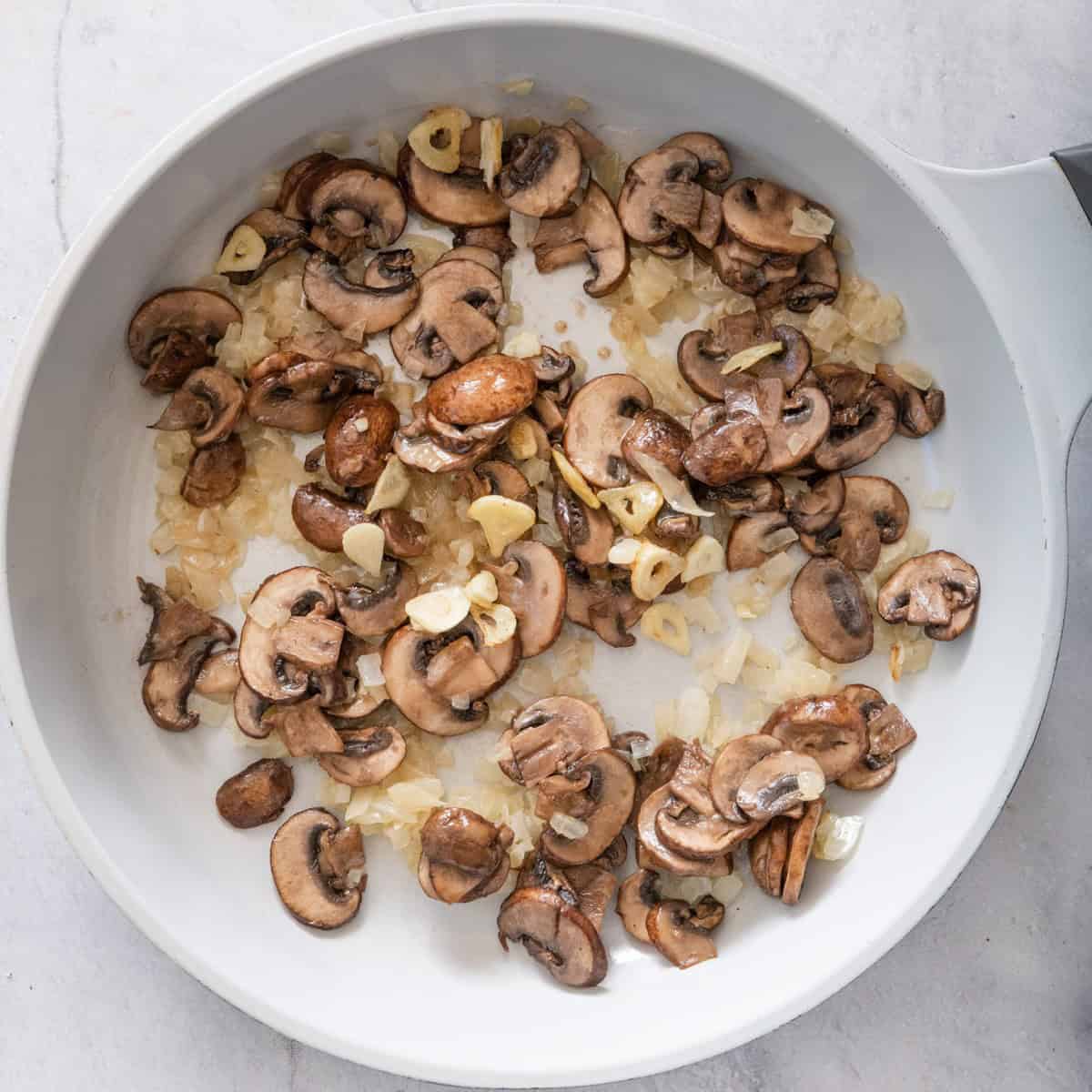 Mushrooms, onions, and garlic in a skillet after cooking.