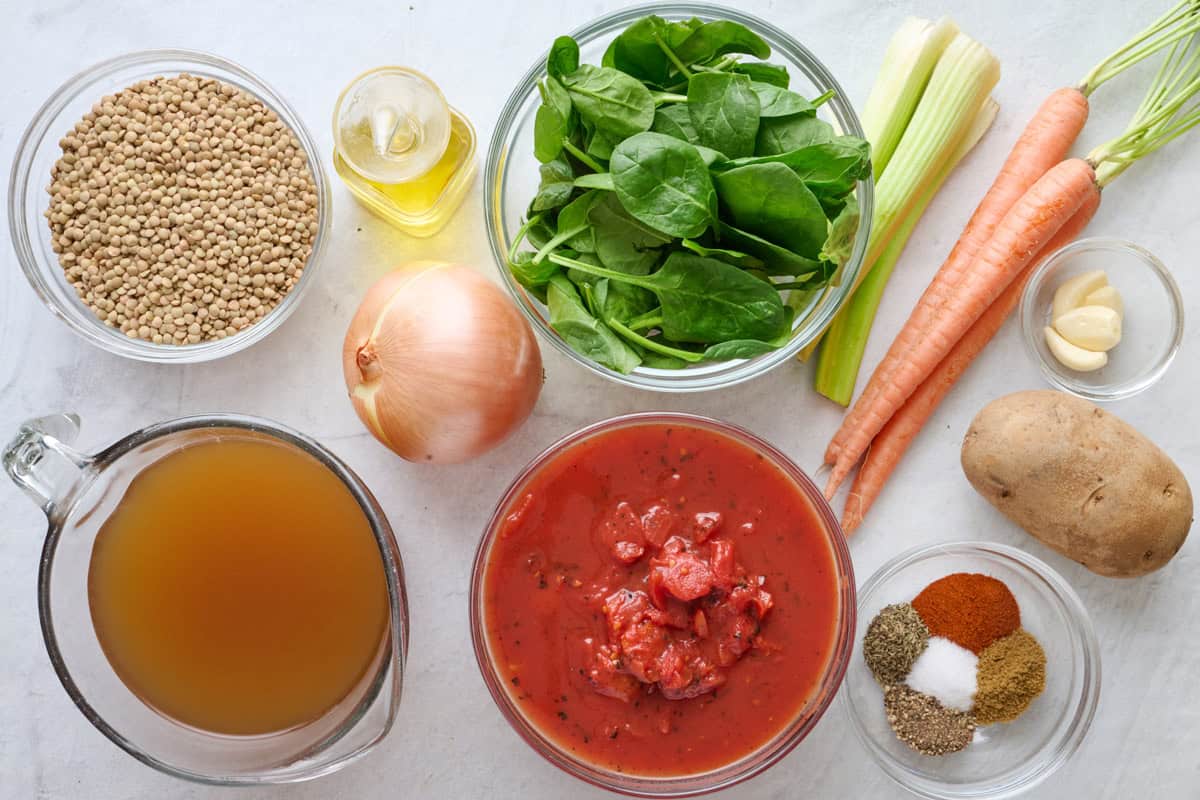 Ingredients for recipe: lentils, broth, oil, onion, fire roasted tomatoes, spinach, celery, carrots, garlic cloves, potato, and spices.
