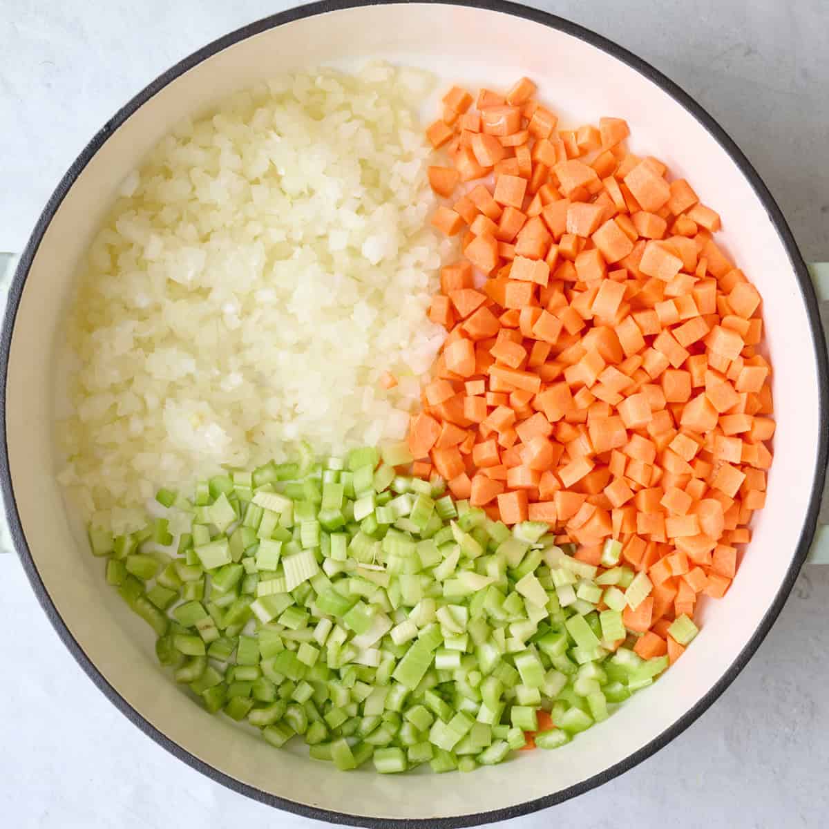 Onions, carrots and celery in a pot.