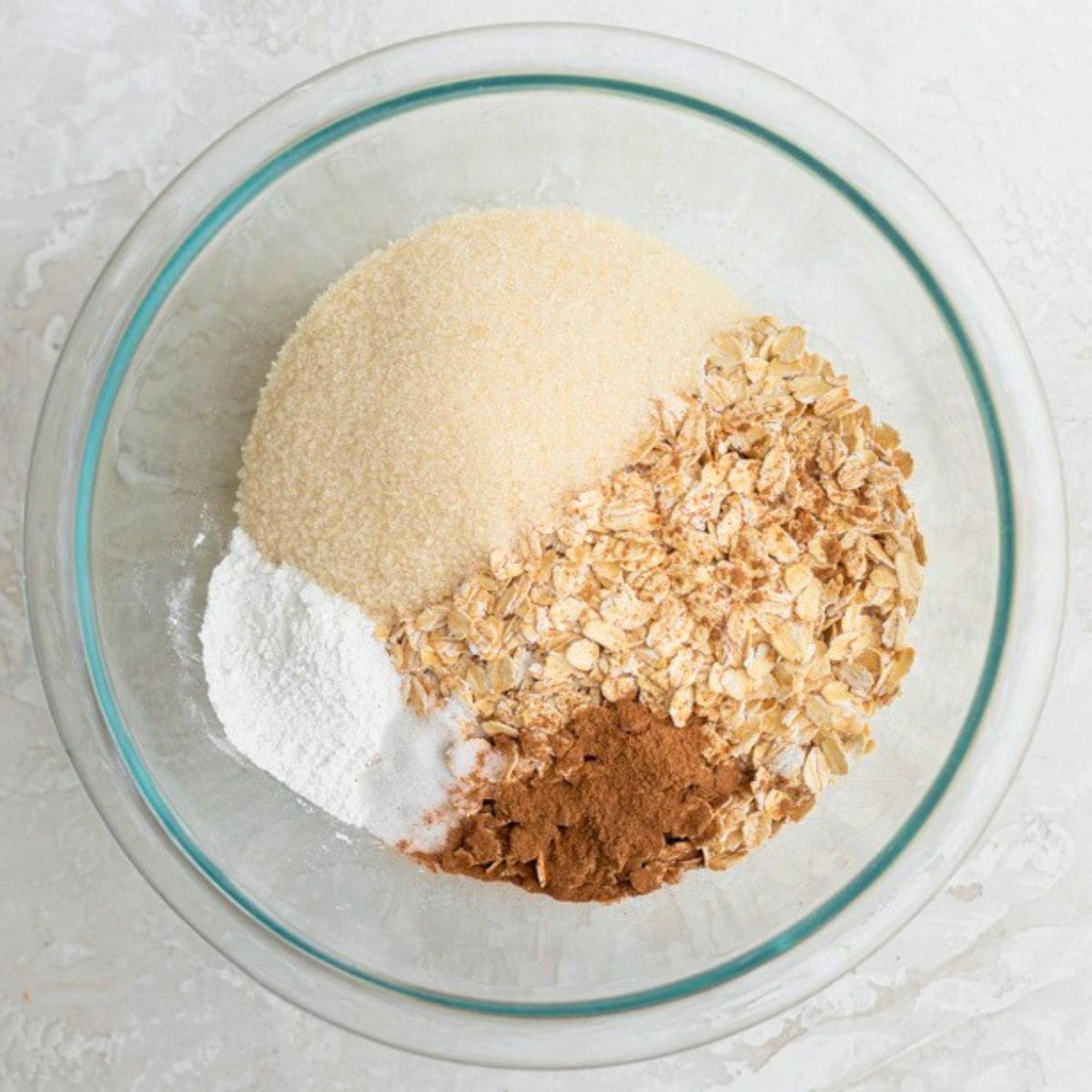 Oats, sugar, cinnamon, baking powder and salt in a bowl.