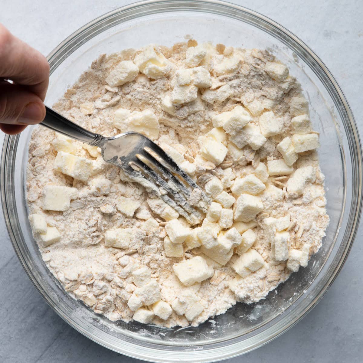 Fork cutting butter into dry ingredients.