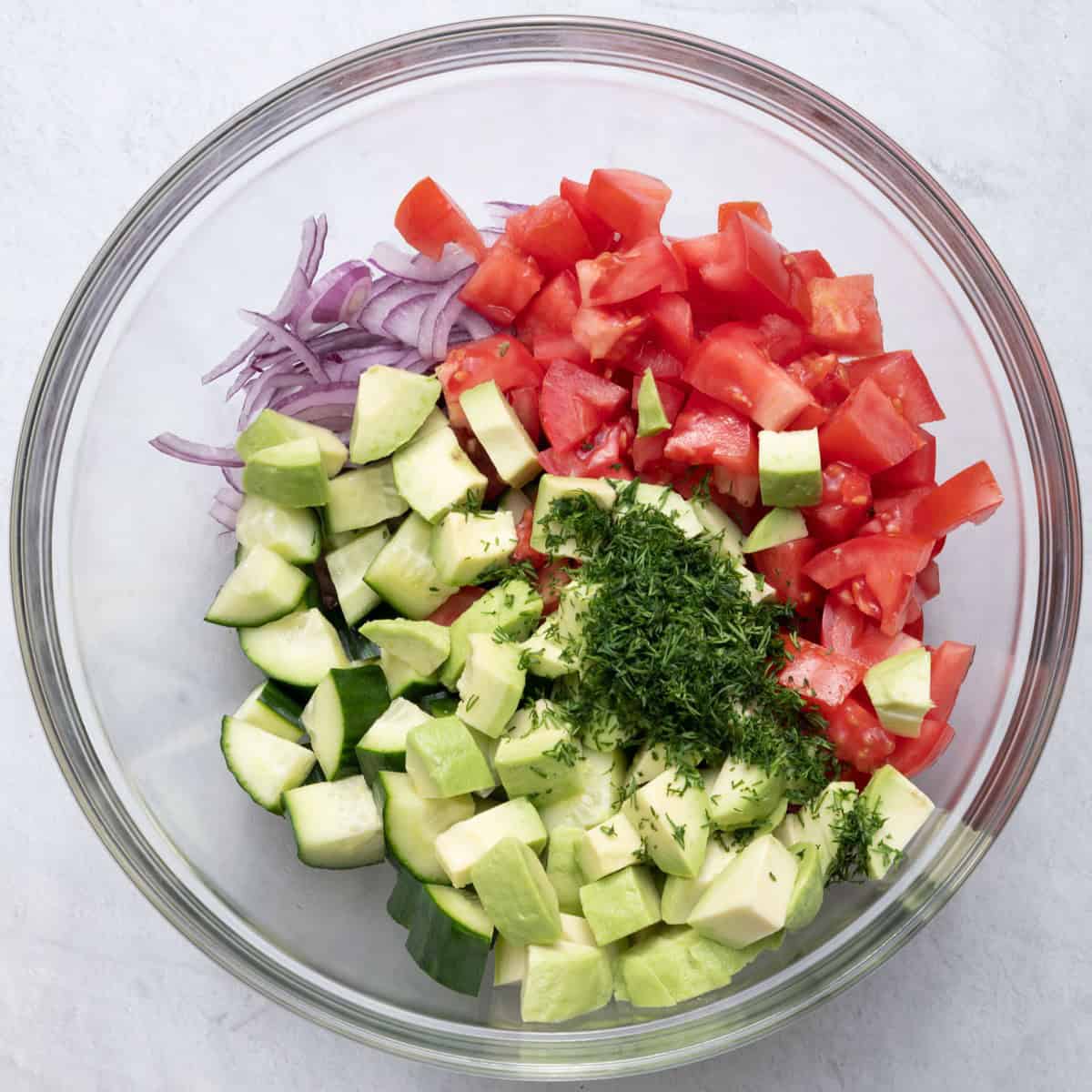 Tomatoes, cucumbers, avocados, onions, and dill added on top.