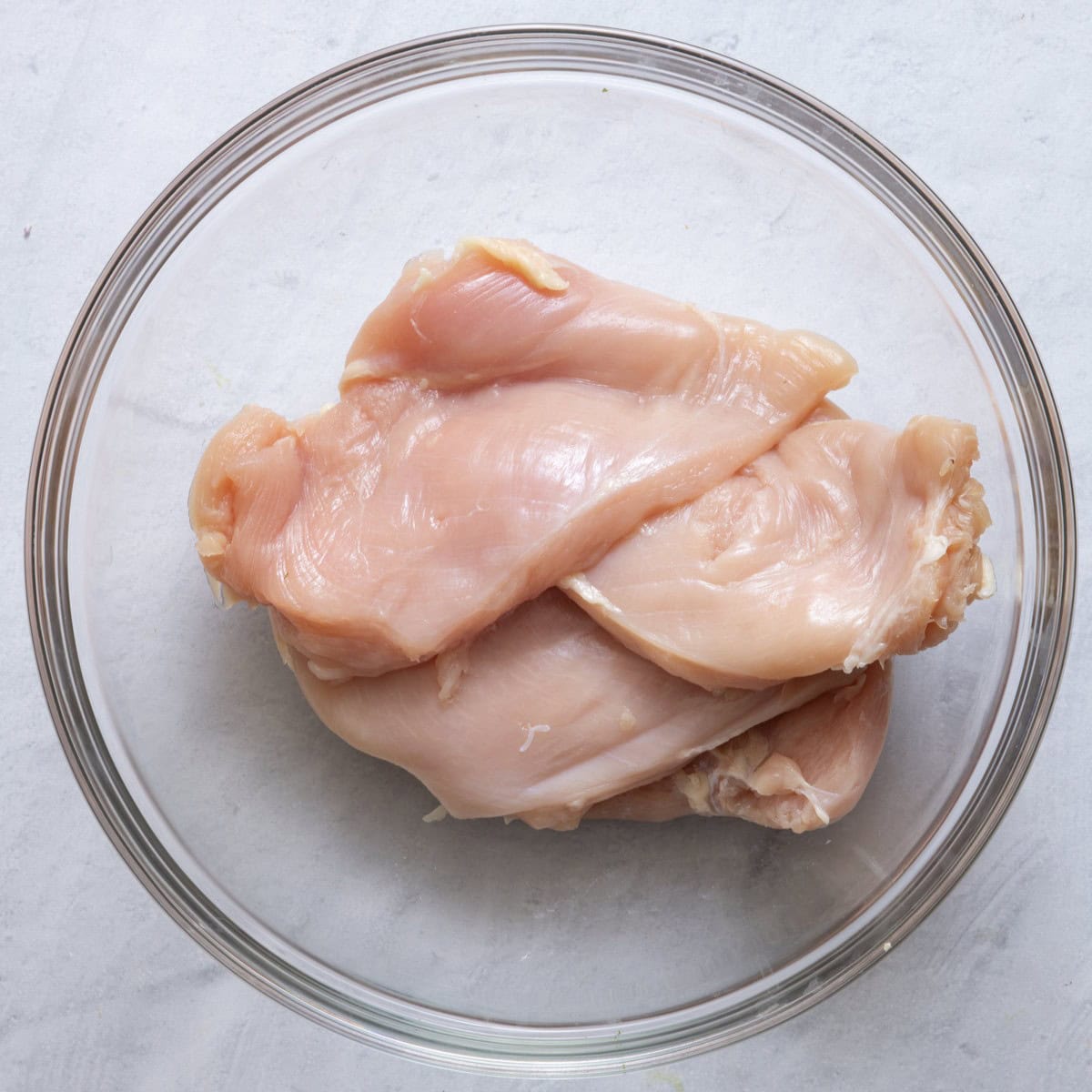 Chicken breasts in a bowl.