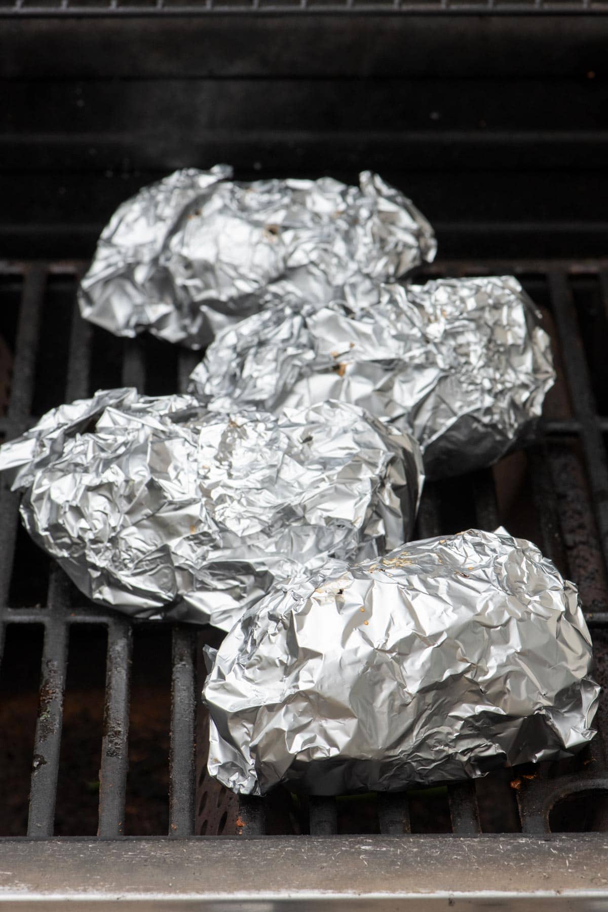 Potatoes wrapped in foil on the grill.