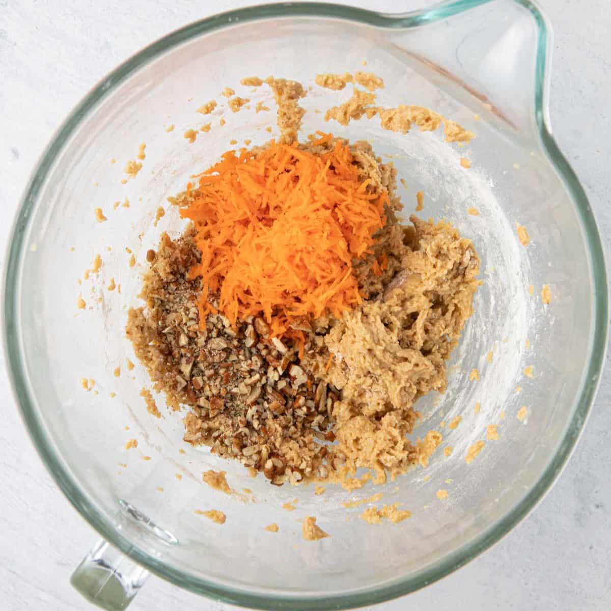 Cookie dough with shredded carrots and pecans added, before mixed.