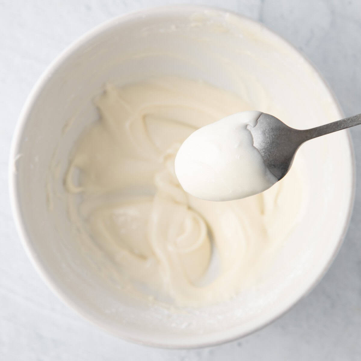 After combined with some on the back of a spoon to show thick but slightly running frosting consistency.