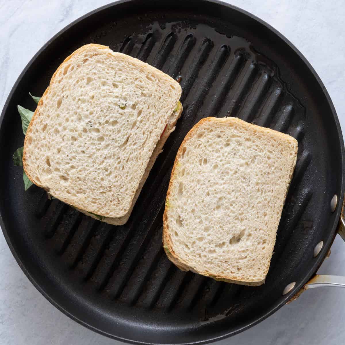 Sandwiches on an oiled pan.