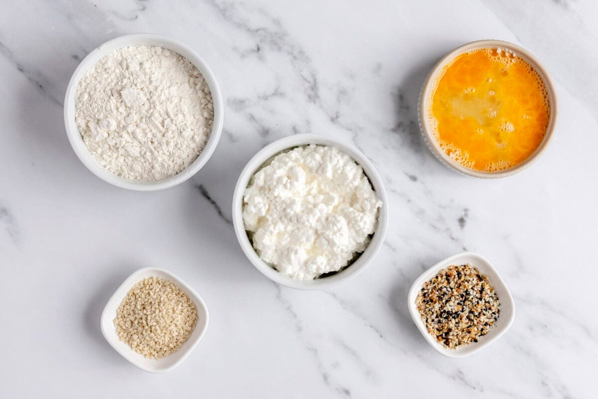 Ingredients for recipe: cottage cheese and self rising flour, plus sesame seeds, everything bagel seasoning, and egg wash for topping.
