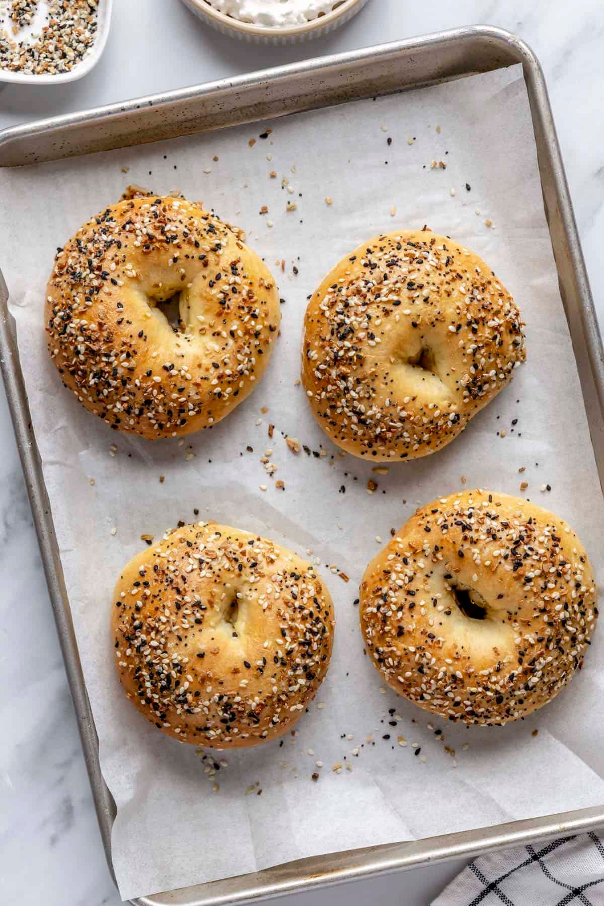Homemade cottage cheese bagels with everything bagel seasoning on a baking sheet.