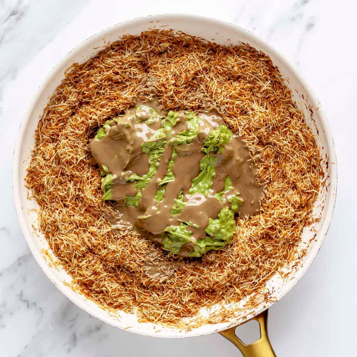 Pistachio butter and tahini added to toasted phyllo in pan.