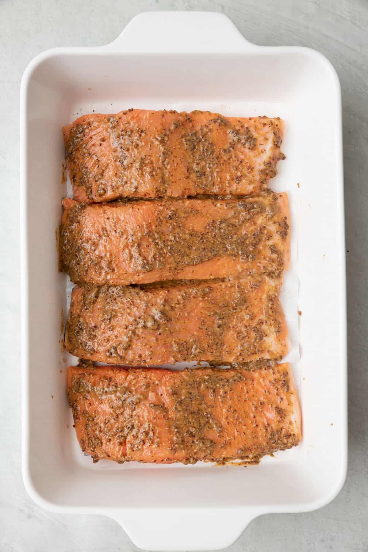 Salmon covered evenly in sauce before baking.