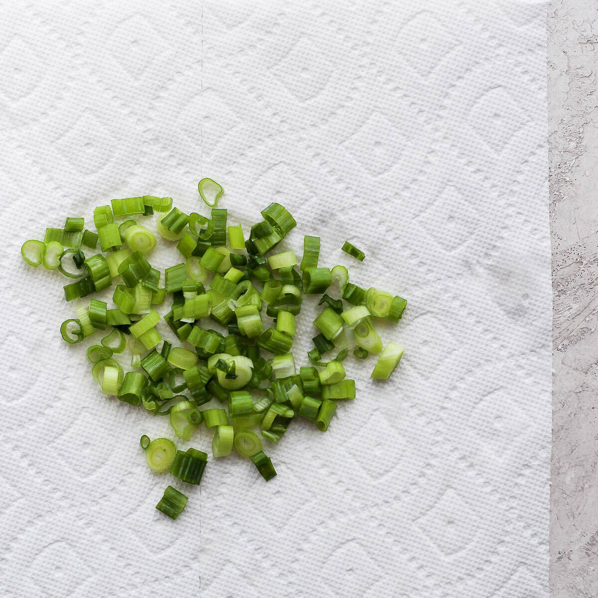 Rinsed green onions drying on paper towel.