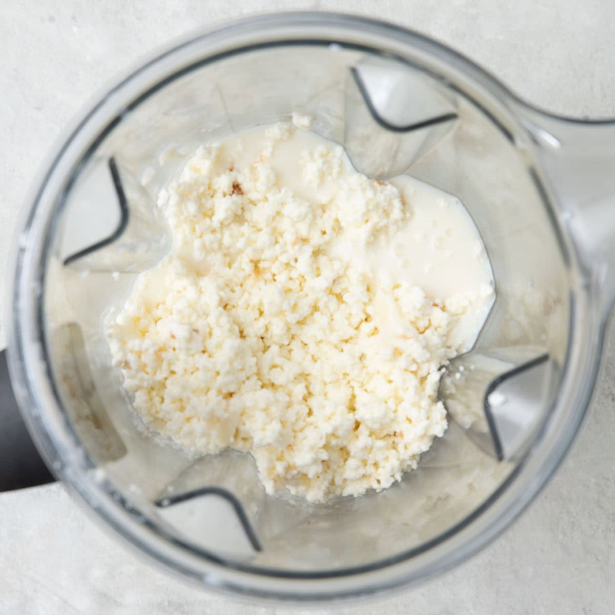 Milk curds and ashta cream in a blender before combined.