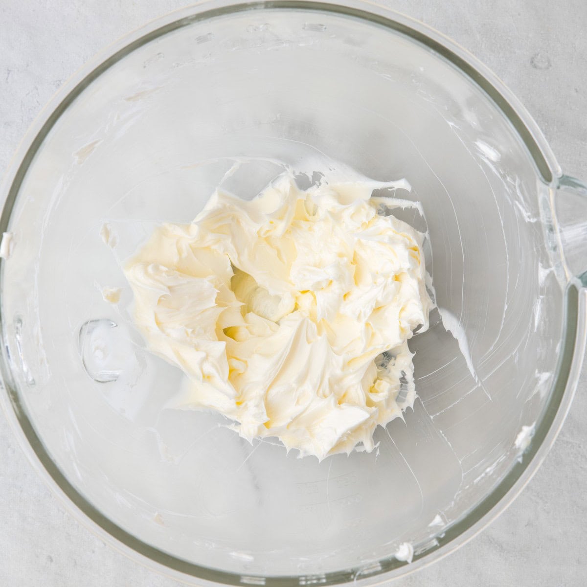Butter in stand mixer bowl after mixed showing light color and fluffy texture.
