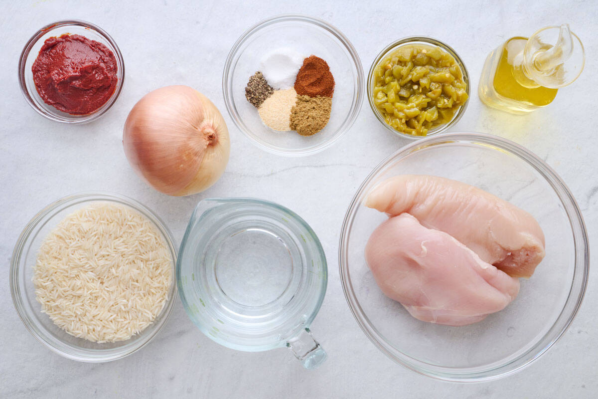 Ingredients for recipe: tomato paste, onion, rice, water, seasonings, green chilis, chicken breasts, and oil.