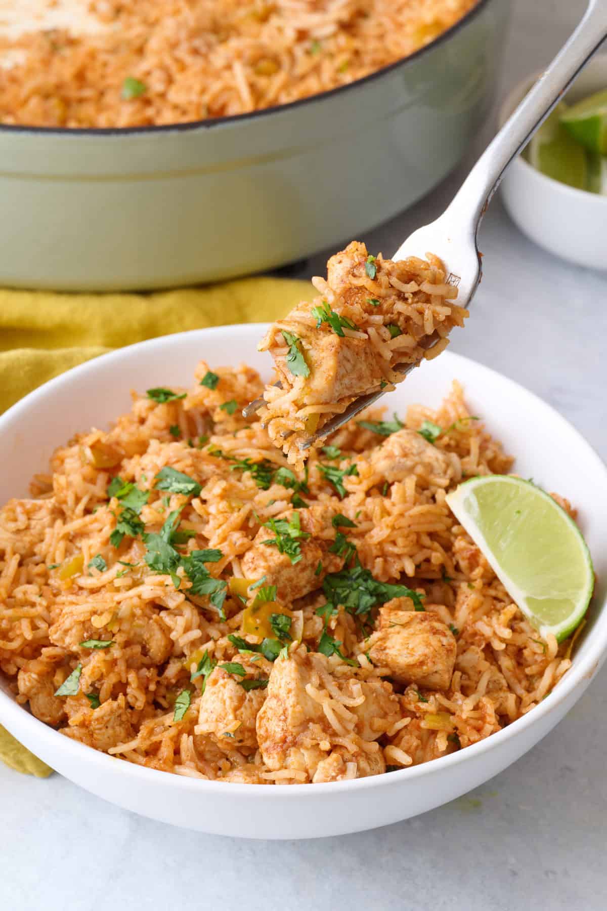 Bowl of Mexican chicken and rice recipe with a fork lifting up a bite.
