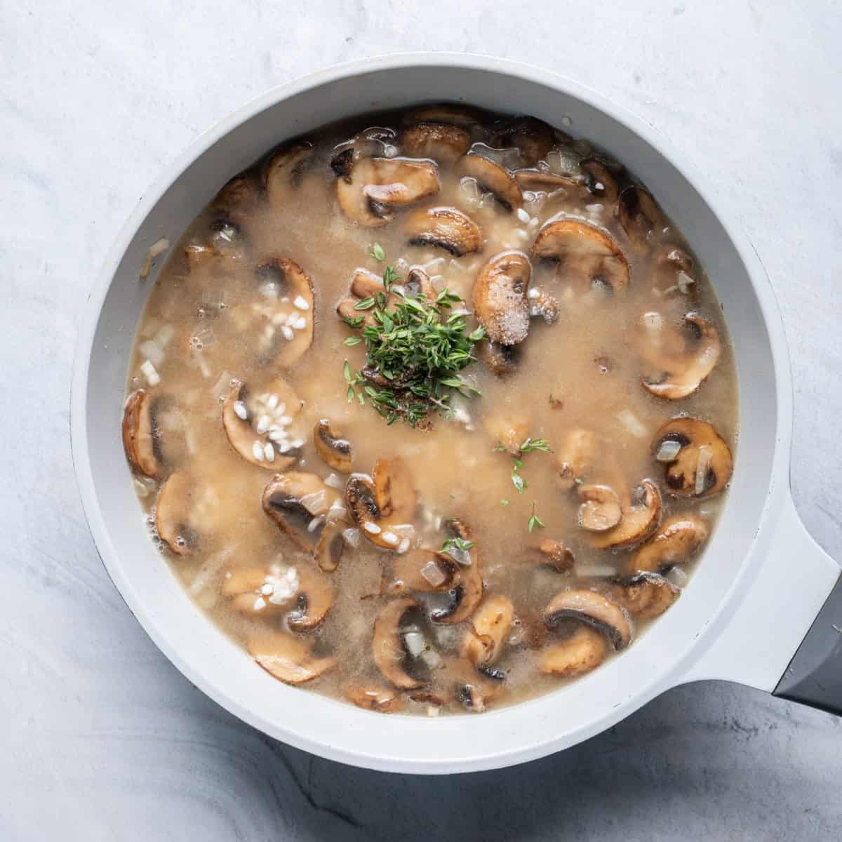 After adding soaked rice in broth to cooked mushroom and onion mixture.