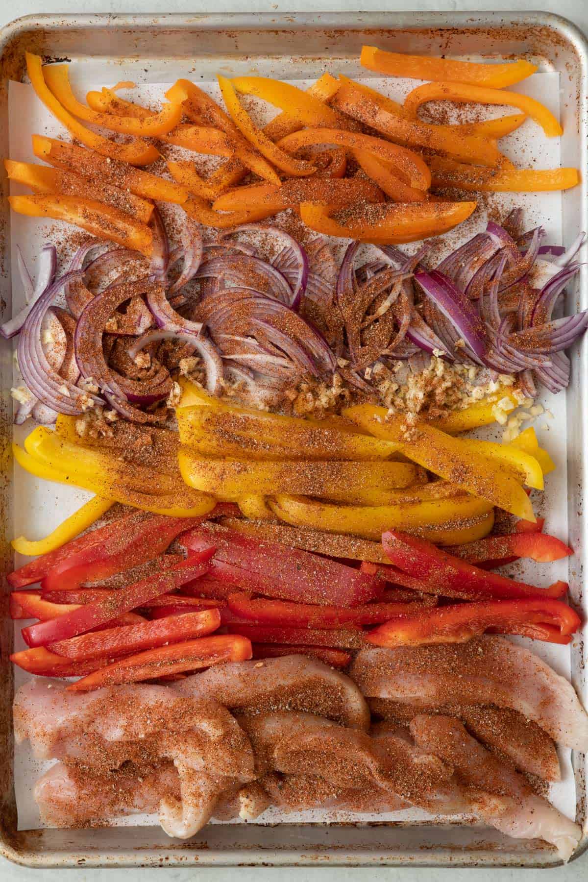 Seasoning sprinkled over chicken and veggies.