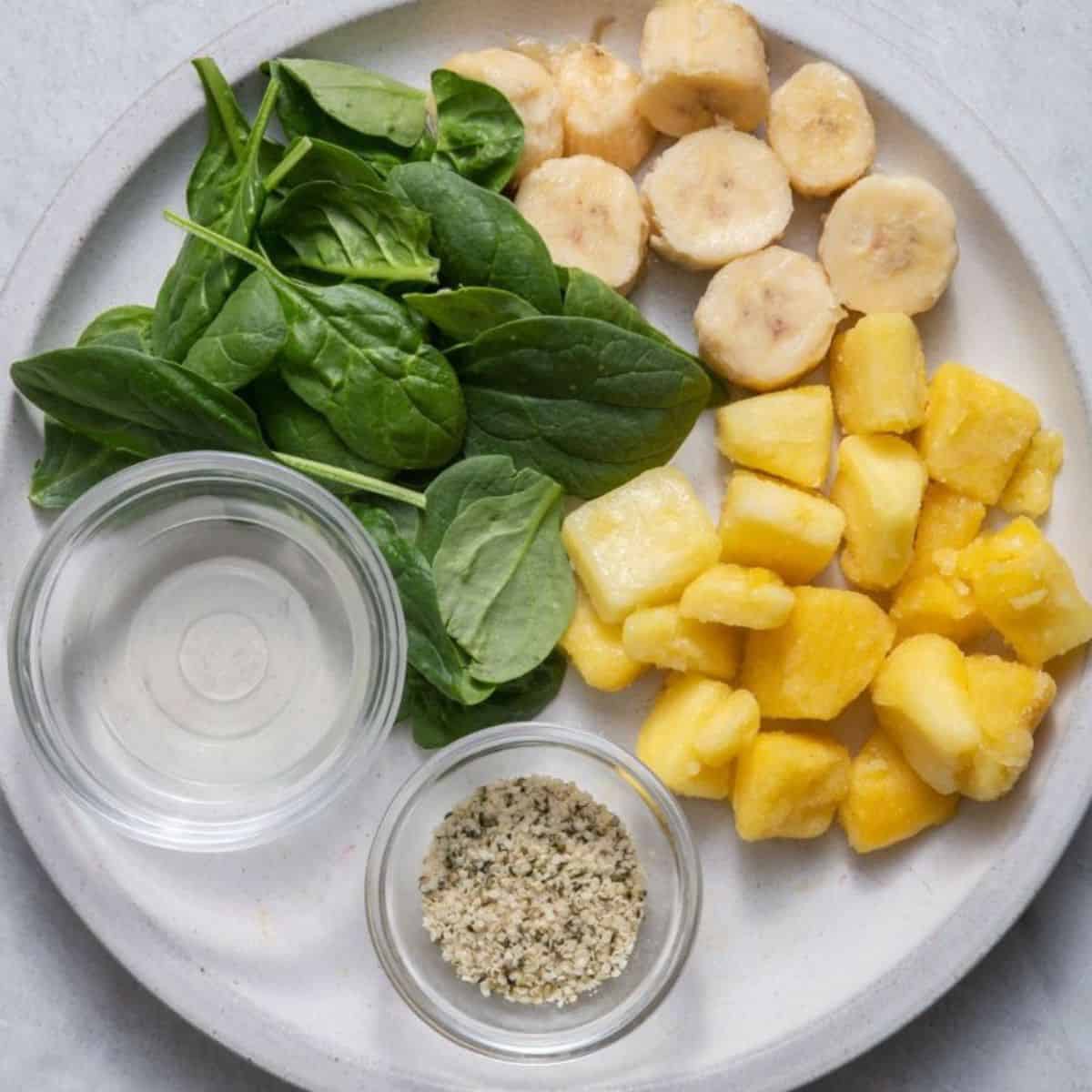 Recipe ingredients: frozen banana, baby spinach, diced mango, coconut oil, and sesame seeds