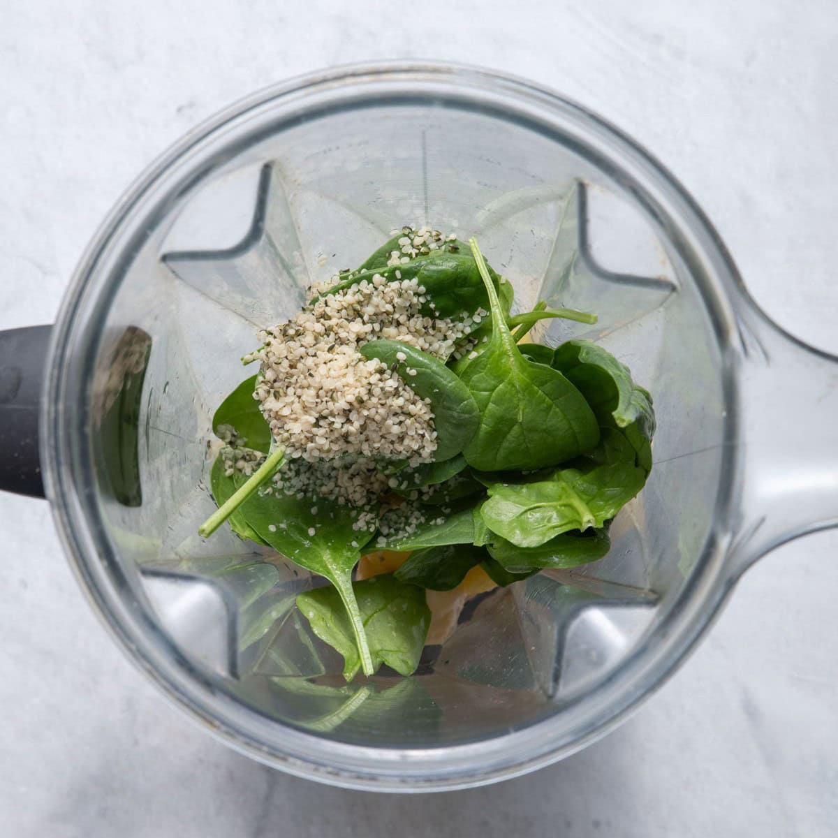 Green machine smoothie ingredients in a blender.