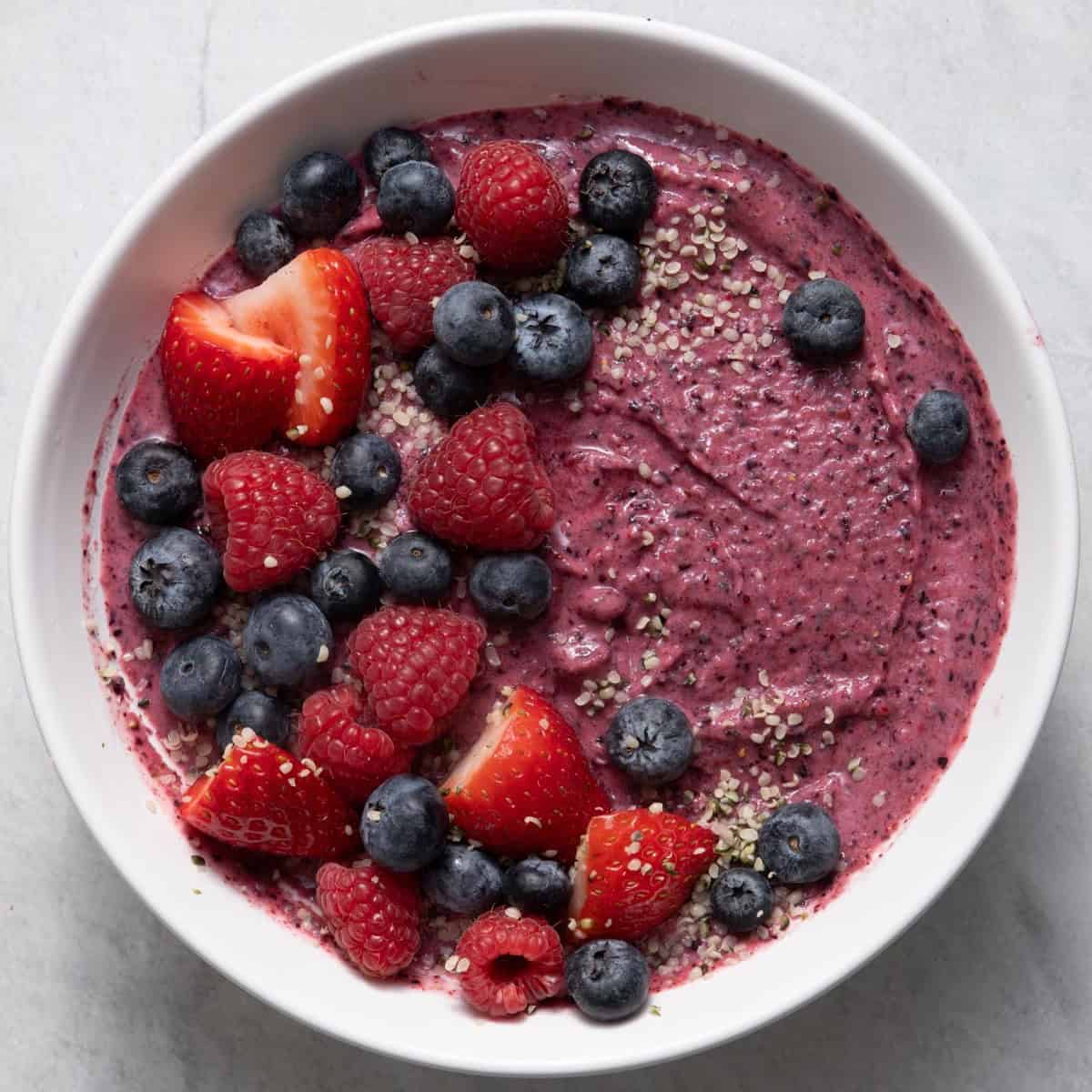 Berry smoothie bowl with chia seeds, fresh blueberries, raspberries, and strawberries.