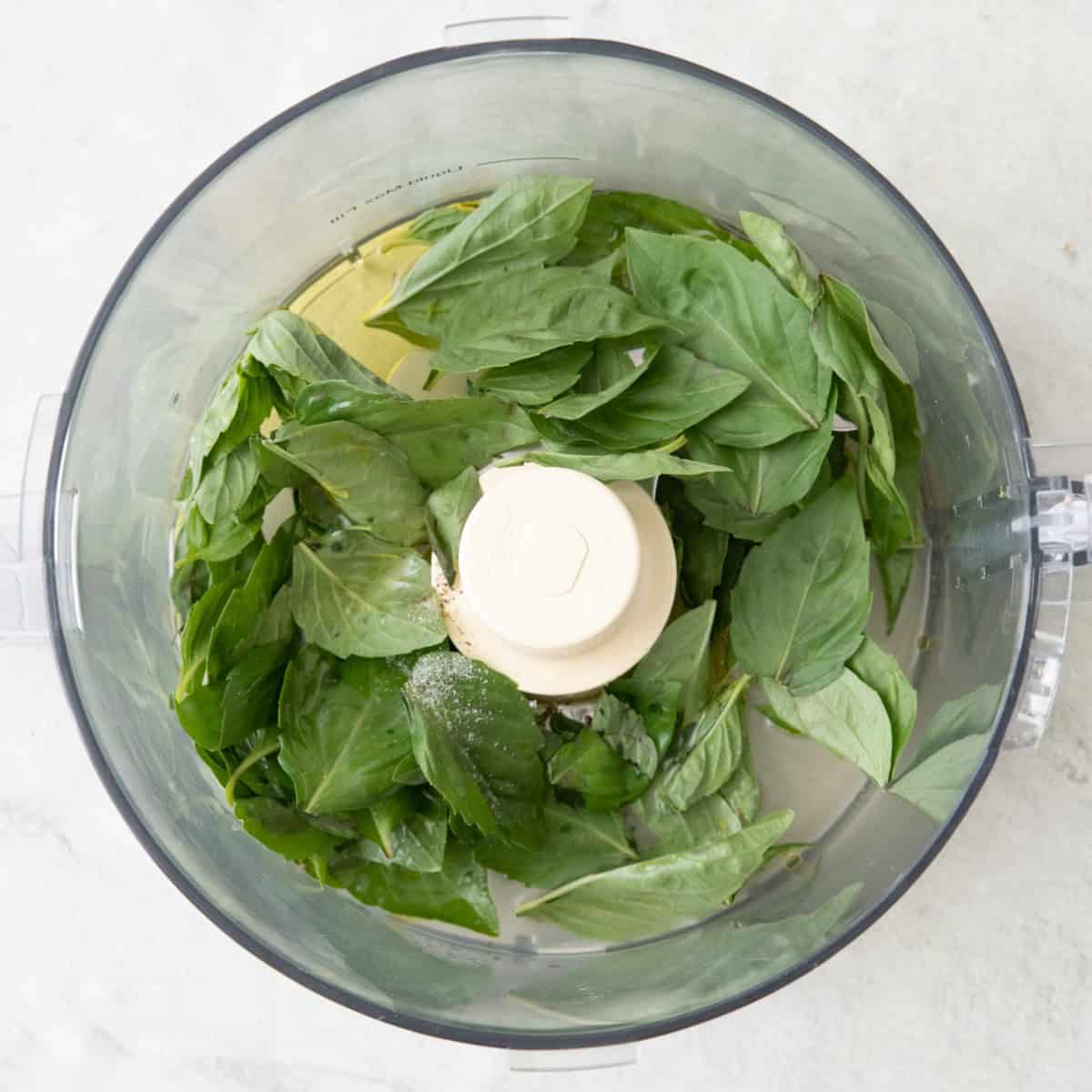 Spinach. basil, seasoning in a food processor.