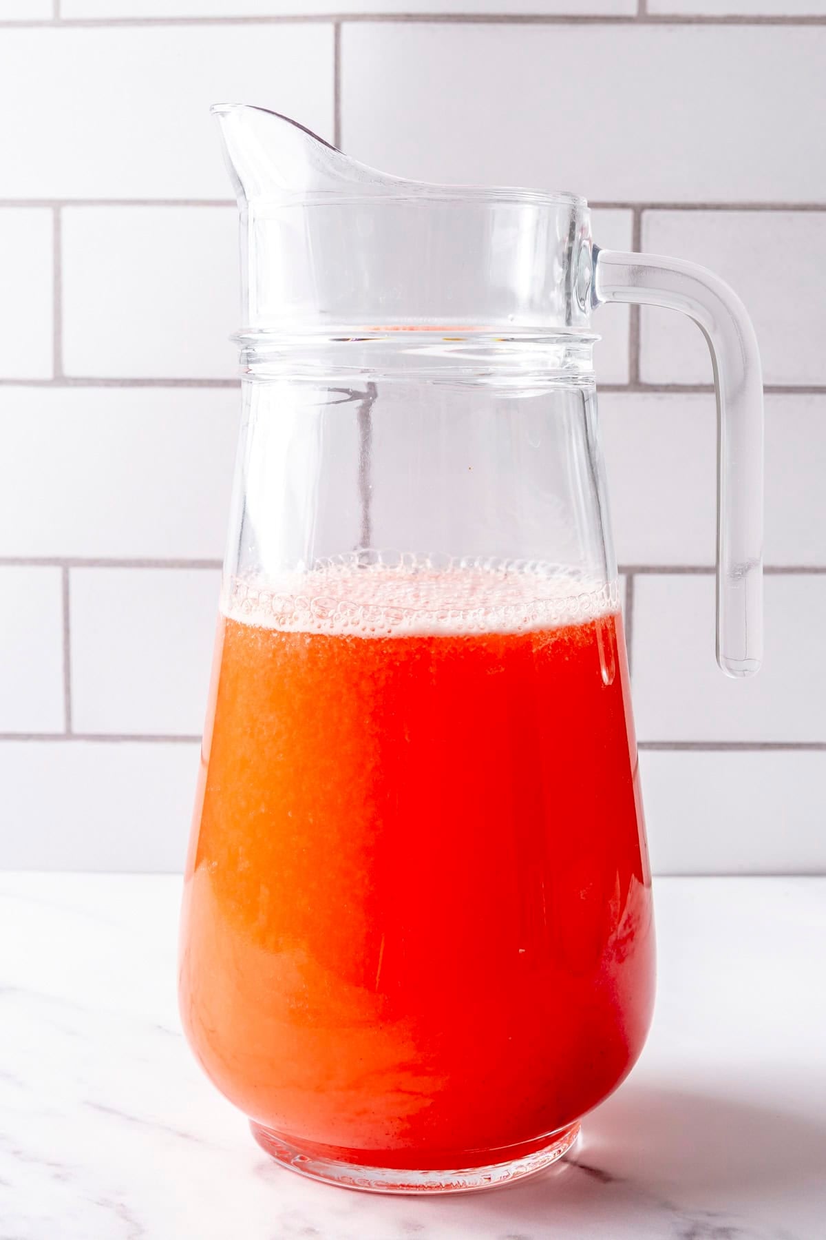 Strawberry lemonade in a pitcher before adding ice.