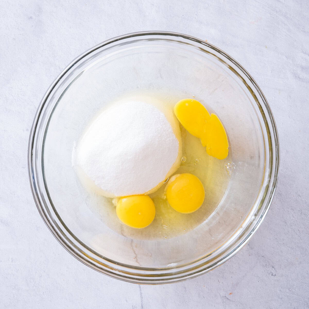 Sugar and eggs in a bowl before mixing.
