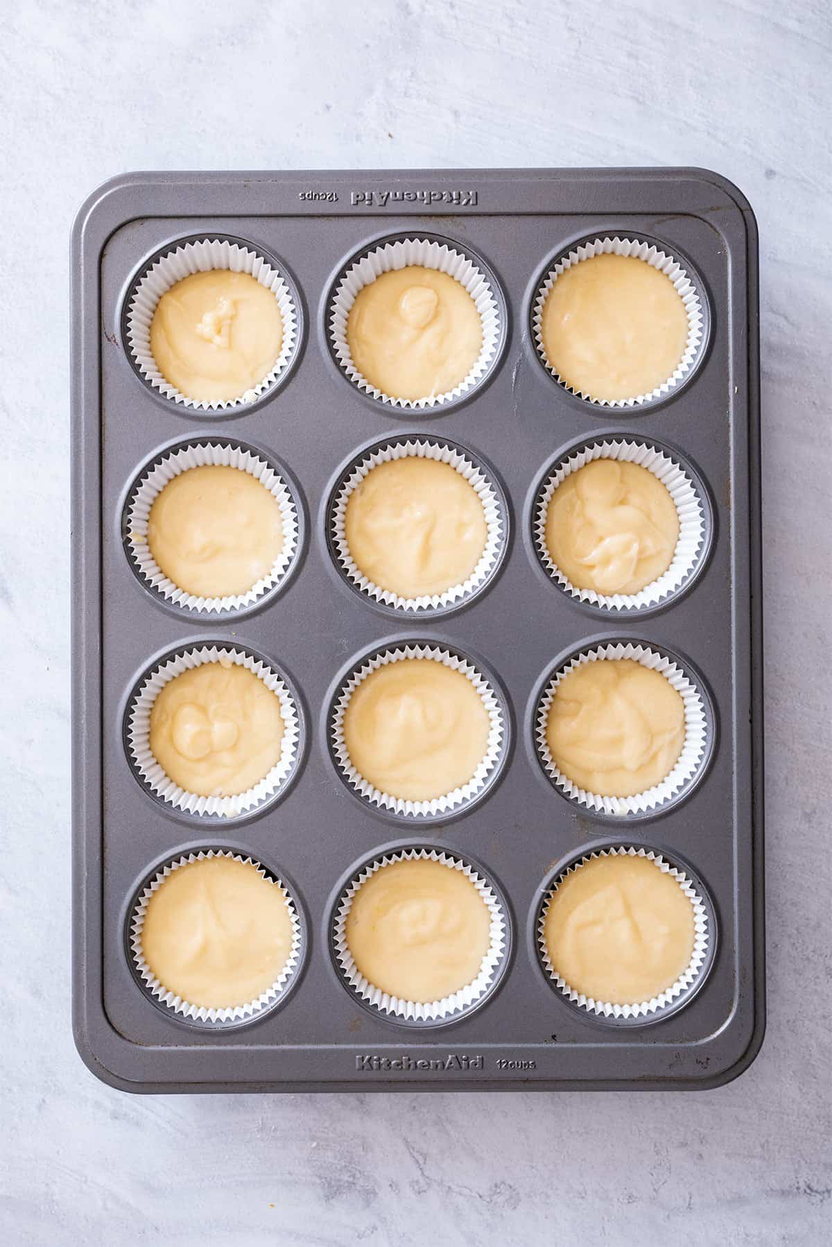 Batter divided into a 12 cup cupcake pan with paper liners.