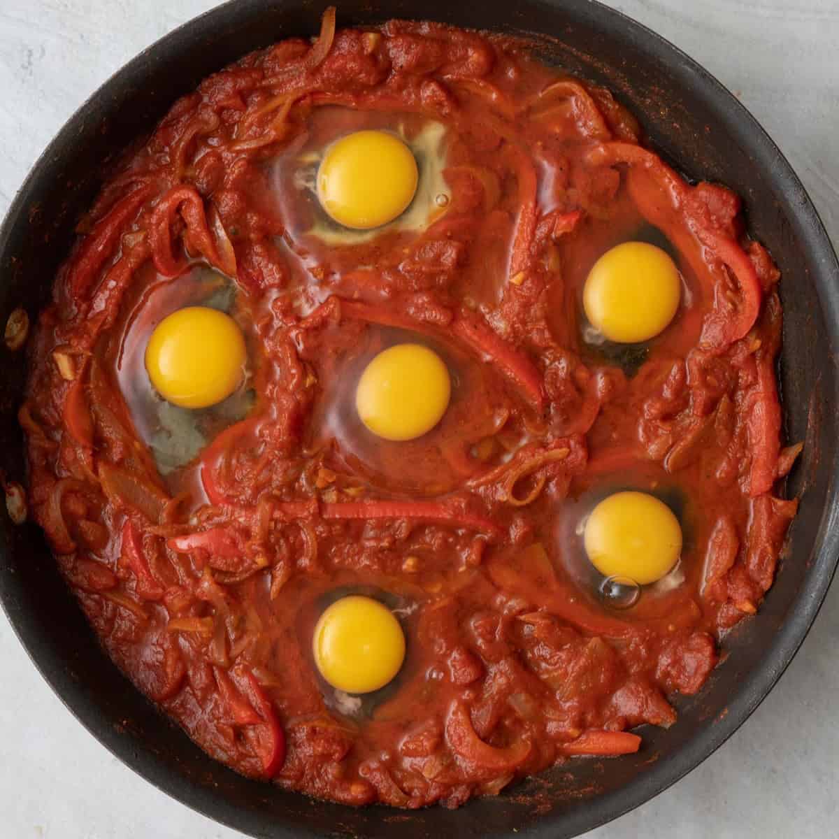 Eggs cracked into stew before cooked.