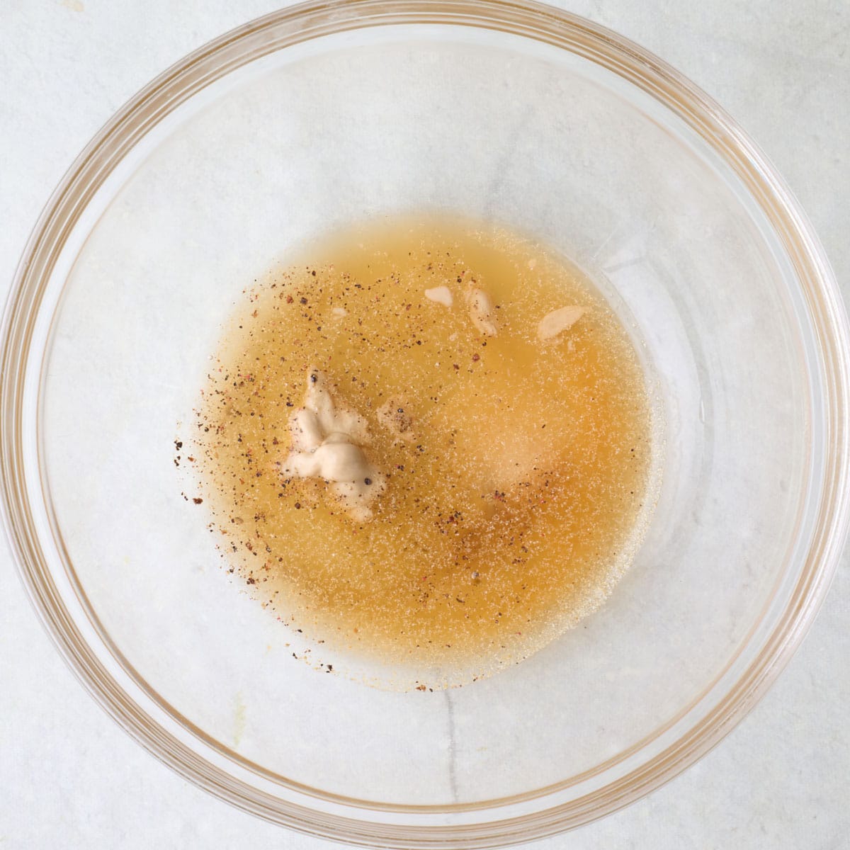 Vinegar, honey, dijon mustard, and seasonings in a small bowl.