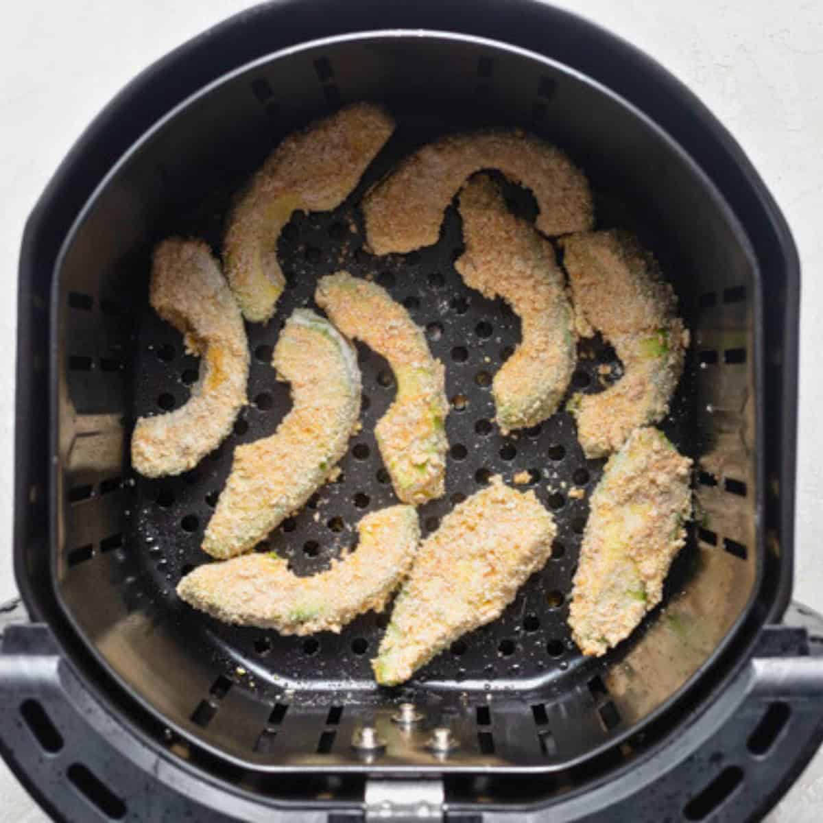 Recipe in an air fryer basket before cooking.