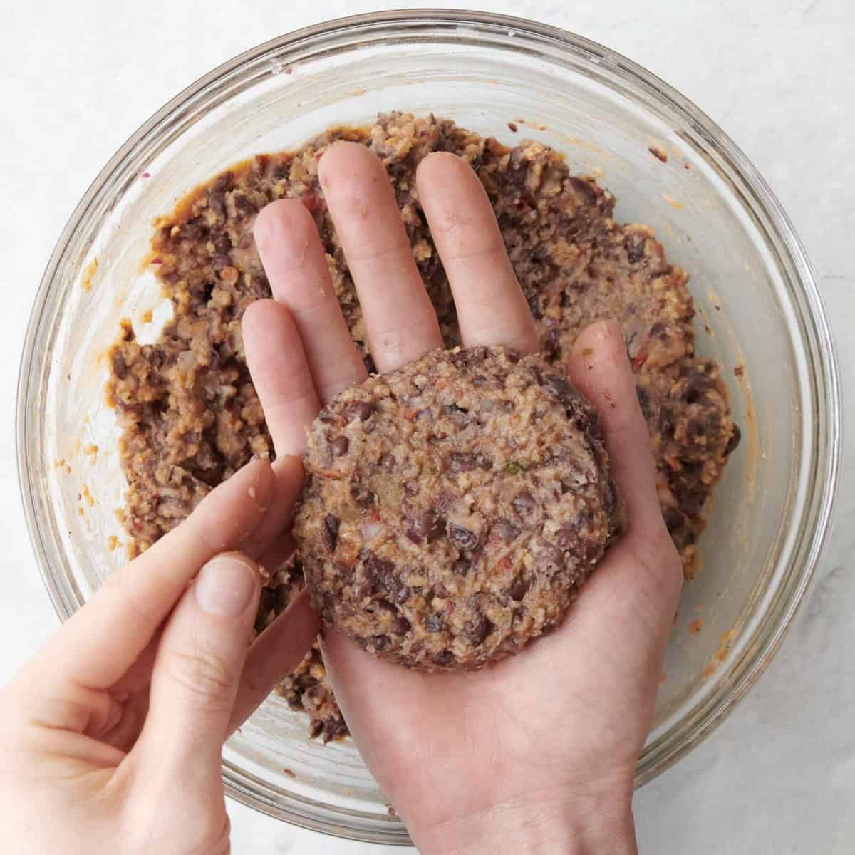 Hand forming some black bean mixture into a patty.