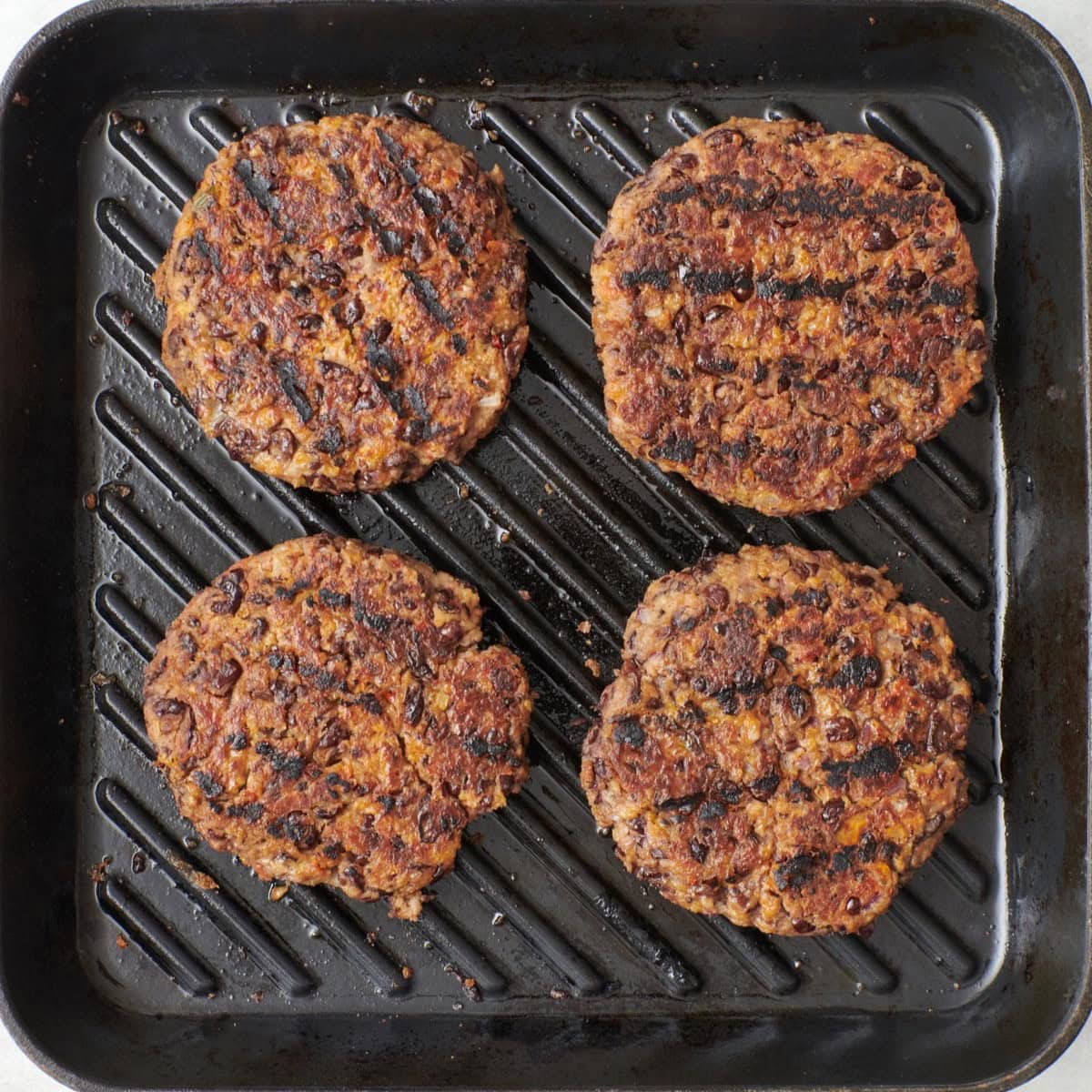 Vegetarian burger patties on a grill pan.