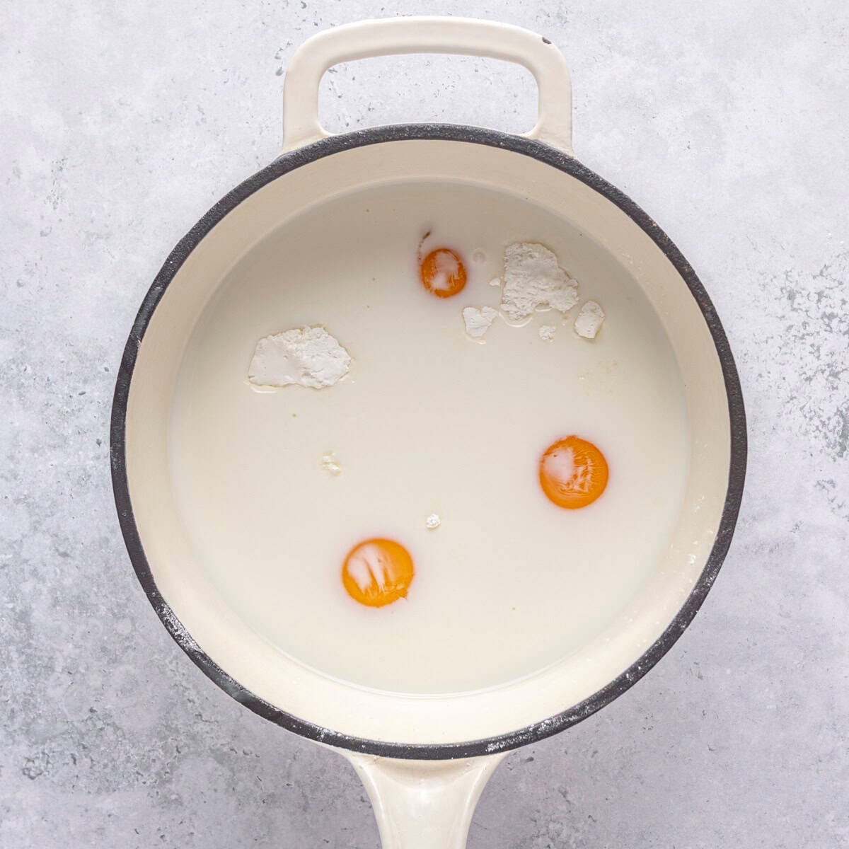 Sugar, cornstarch, milk, egg yolks and salt in a saucepan before mixing.