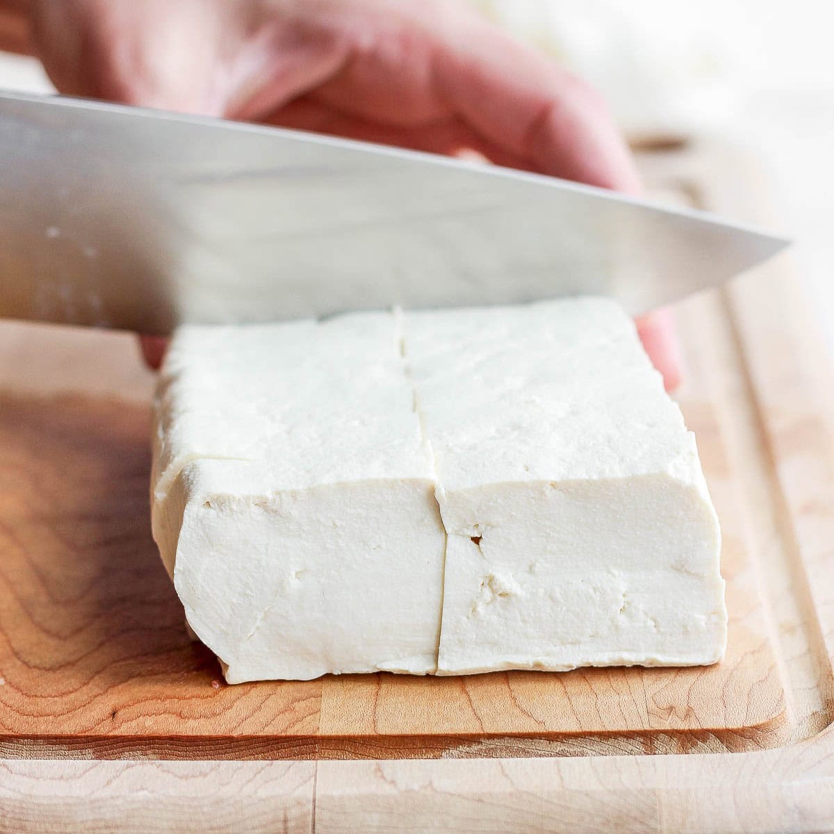 Cutting pressed tofu into slices.