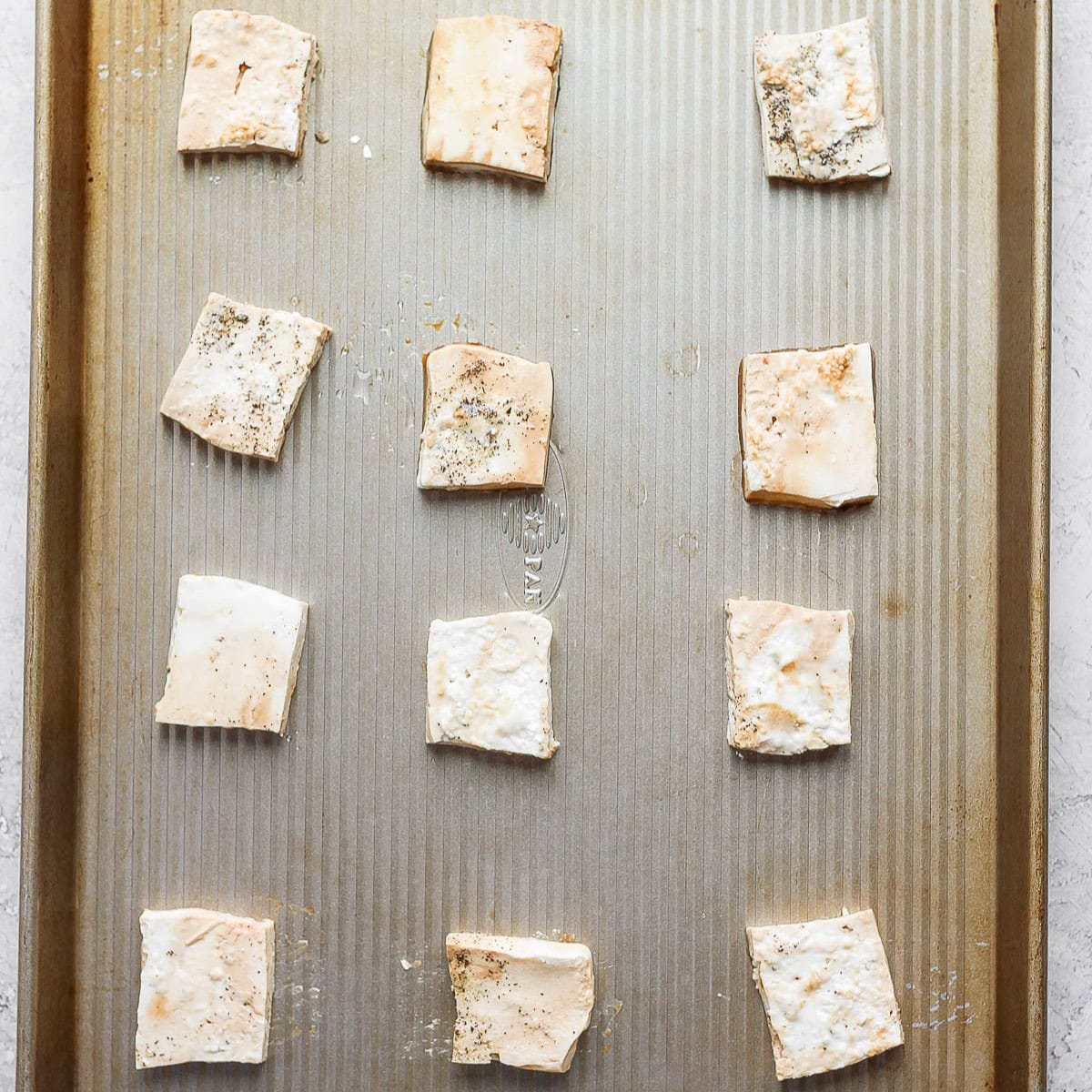 Seasoned recipe pieces on a sheet pan before baking.