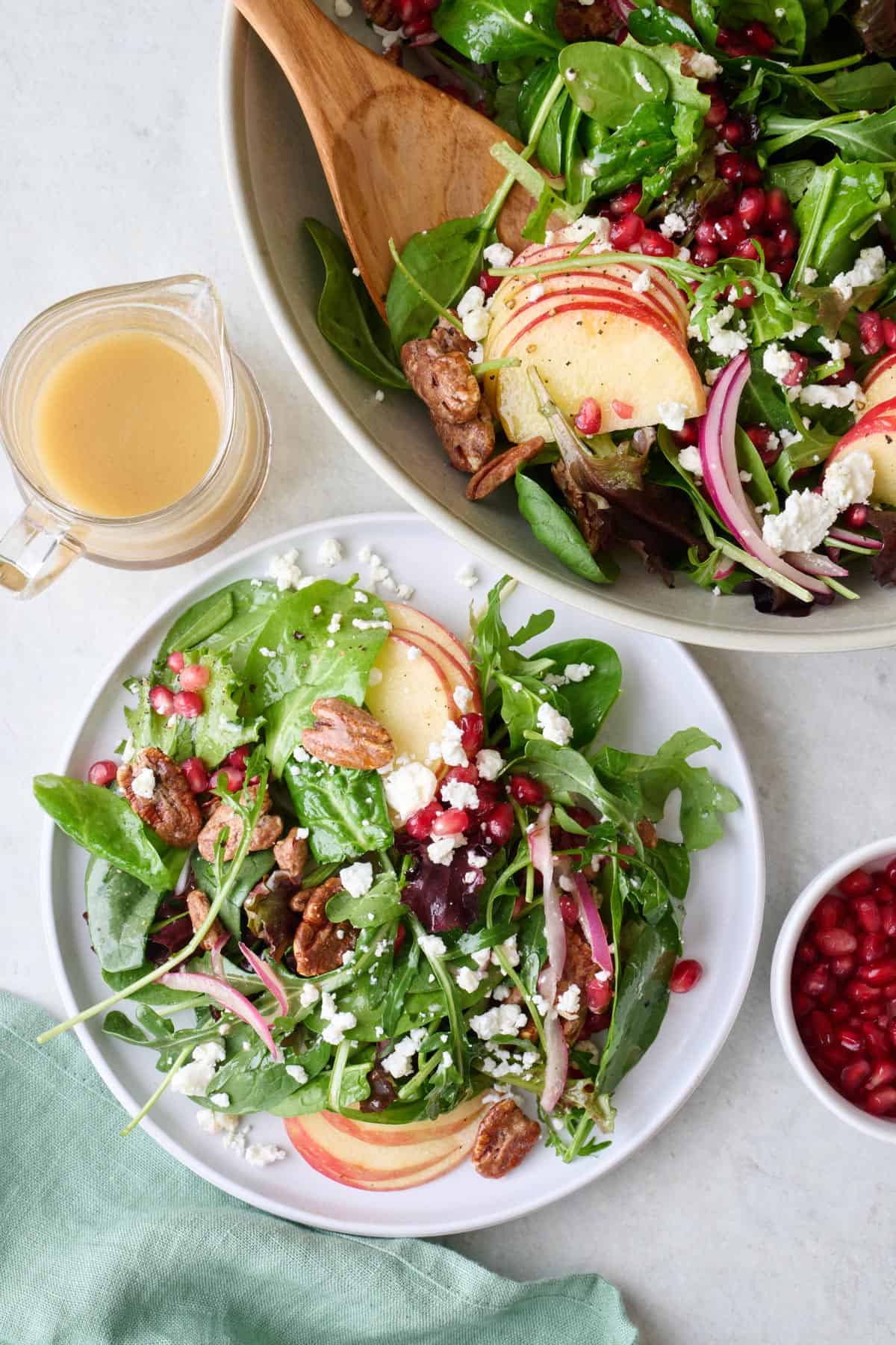 Easy pomegranate salad on a small plate next to salad bowl.