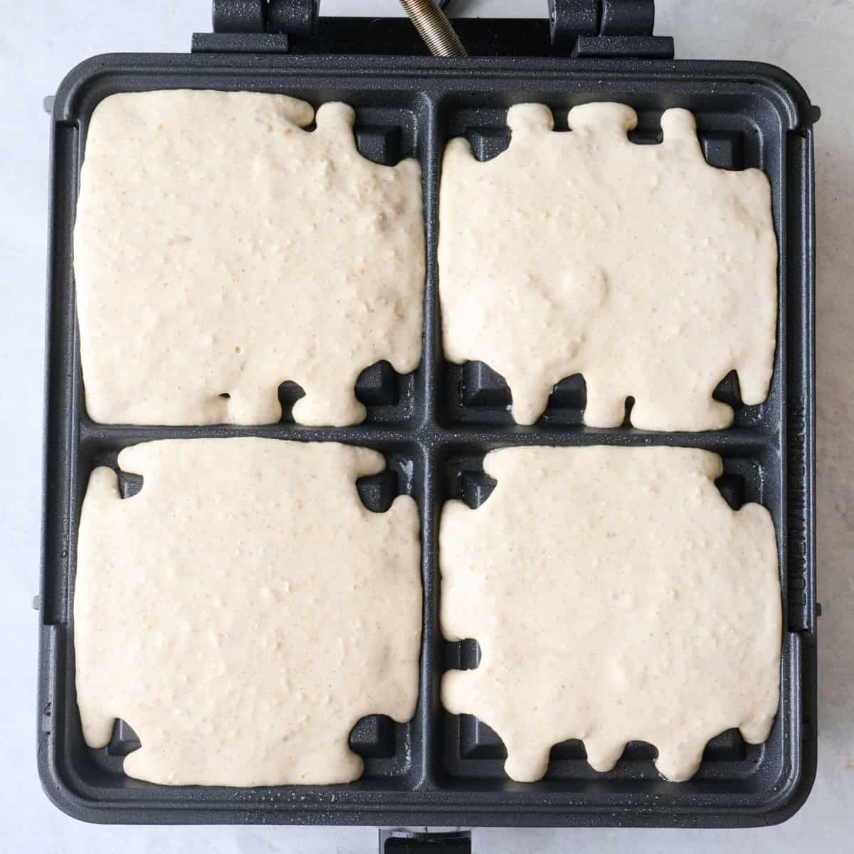 Waffle batter added to a waffle iron.