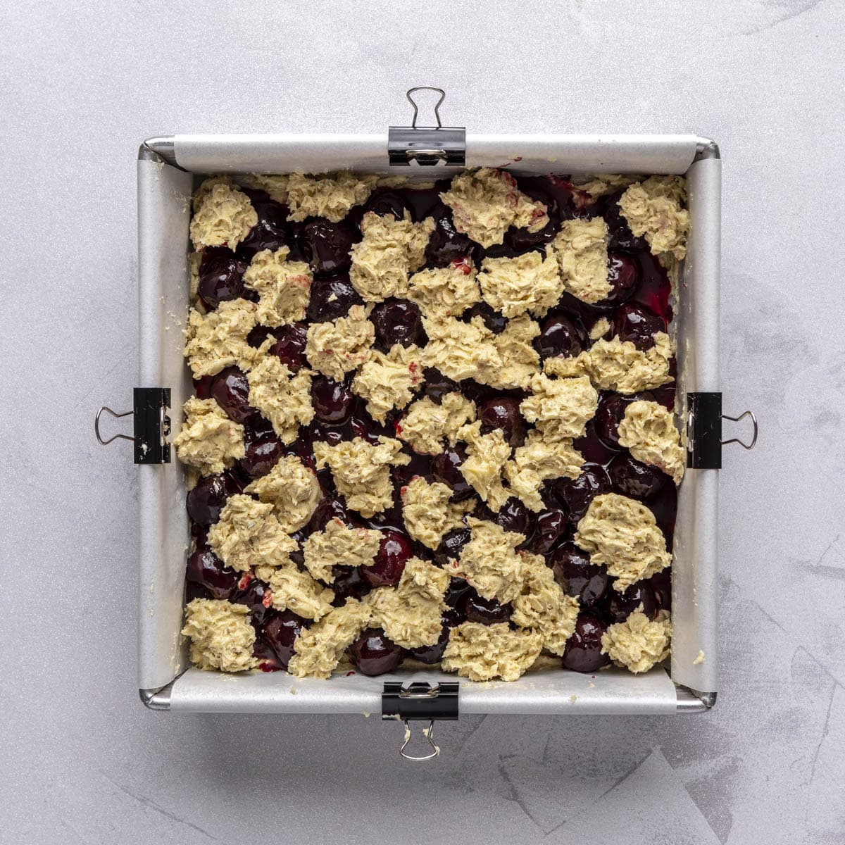 Topping dough dropped over cherry filling.