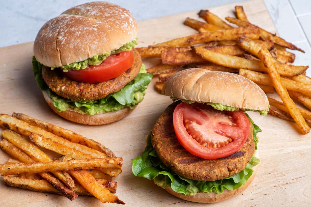 Homemade chickpea burgers assemble on a bun served with fries.