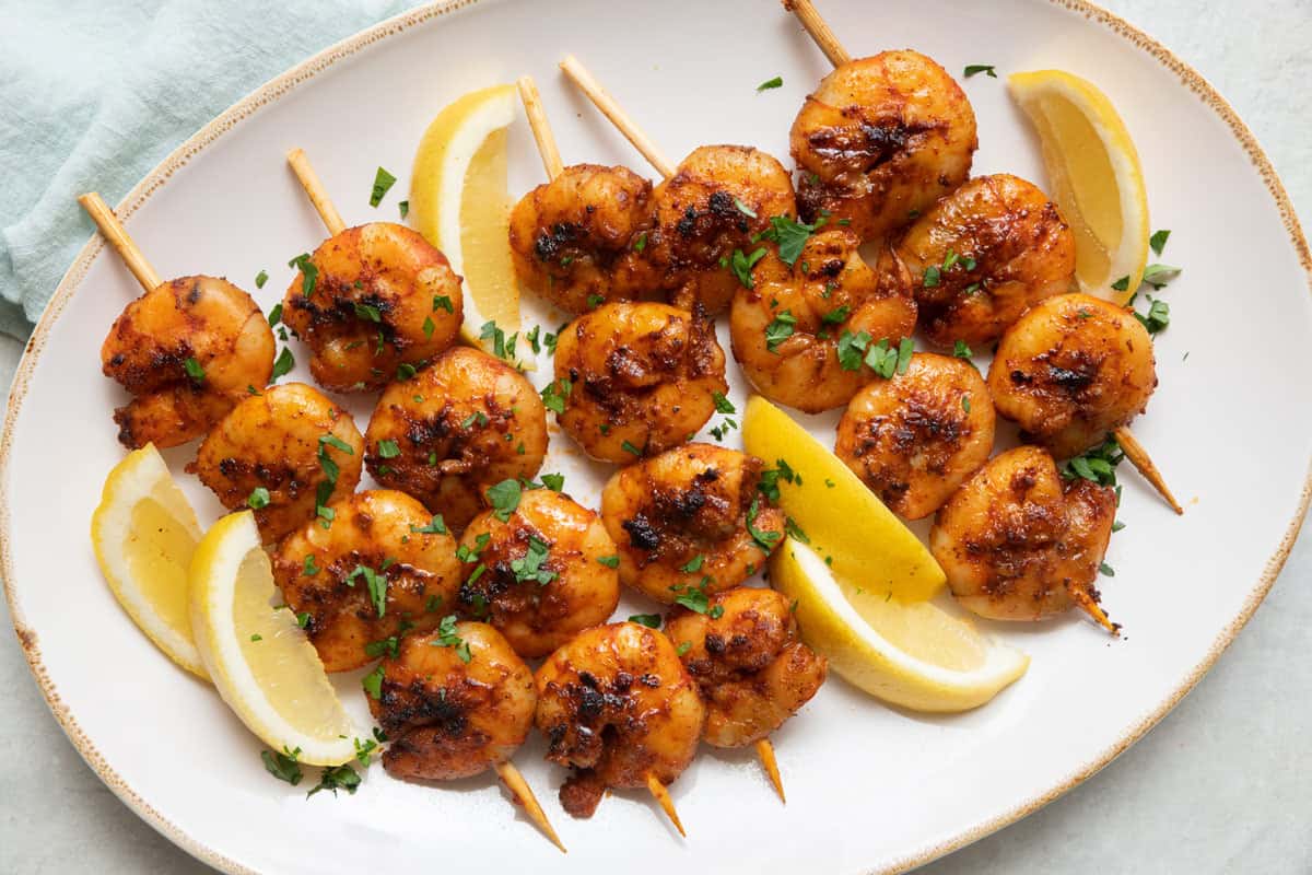 Grilled bbq shrimp skewers on a platter.