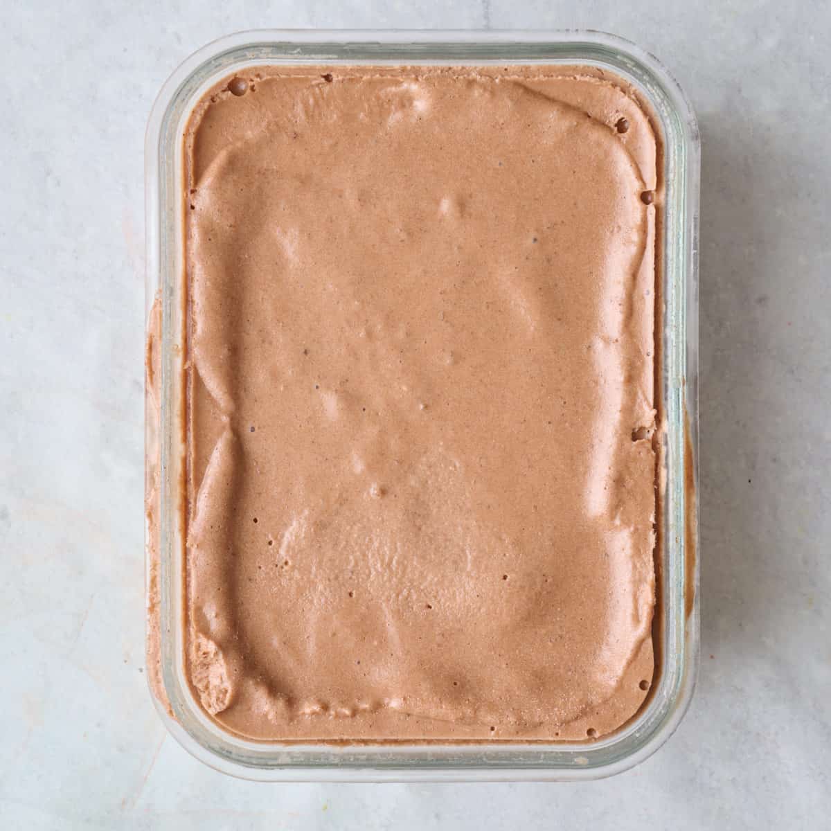 Frozen chocolate protein ice cream in a small glass dish.
