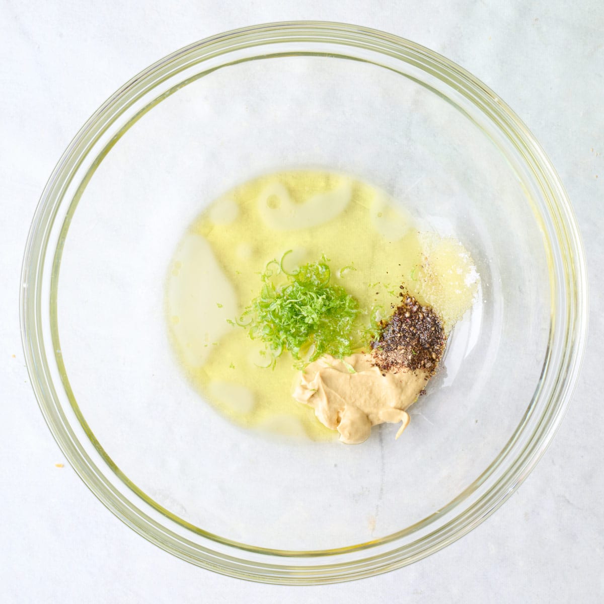 Dressing ingredients in a bowl before mixing.